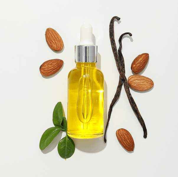 Golden perfume oil with almonds, leaves, and vanilla pods